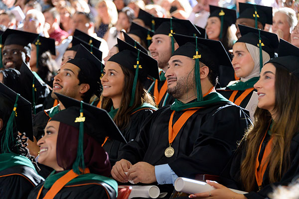 A crowd shot of smiling graduates looking off to the left