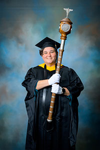 Sarah-Burnett-Greenup-sf Sarah-Burnett-Greenup in commencement regalia holding the ceremonial mace