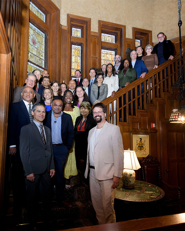 New UTMB professors stand along the staircase at Open Gates