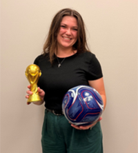 Student winner Winner Lauren Gansereit holds a trophy in her right hand and a soccer ball in her left