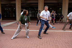 Two UTMB staff members perform lateral lunges as part of their warmup before a group walk