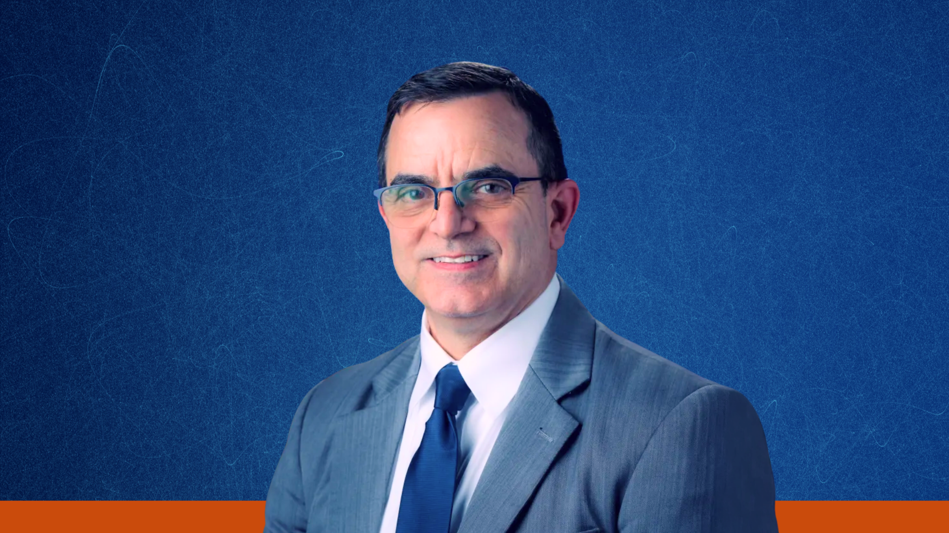 Dr. J.D. Polk's headshot on a dark blue background with an orange stripe along the bottom