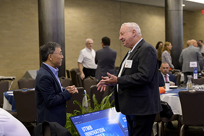 Two men in suits talking at the innovation summit