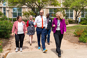 Weds-walk---SF A group of UTMB employees walks along the sidewalk next to the Galveston National Lab.