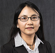 Picture of a woman with long dark hair and glasses wearing a polka dot shirt