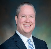 Picture of a man smiling wearing a suit