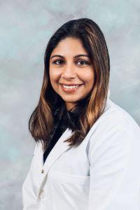 professional picture of Dr. Vidarshi Muthukumarana wearing a white lab coat