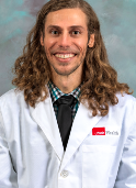 Image of a man smiling in a UTMB white lab coat