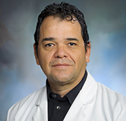 Picture of a man in a white lab coat with short dark hair