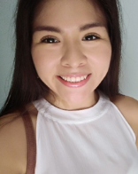 Picture of a woman smiling wearing a white sleeveless shirt
