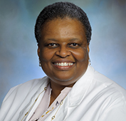 Picture of a woman smiling wearing a white lab coat