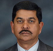 Picture of a man with a mustache wearing a dark suit