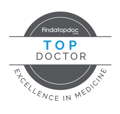 Circular “Top Doctor” badge from Findatopdoc.com featuring gray and white design with blue accent text and the phrase “Excellence in Medicine” around the border.