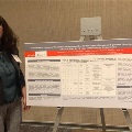UTMB pathology resident Alison discussing her research at a conference poster session, showcasing academic work in a professional setting.