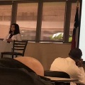 UTMB pathology resident presenting at a podium in a classroom setting, with a projected slide showing histology imagery and attendees seated and listening during an educational lecture.