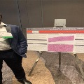 UTMB pathology resident standing next to a research poster on hepatitis C reactivation, displayed on an easel with histology images and clinical findings during a medical conference.