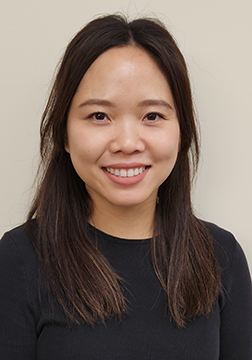 Picture of a woman smiling with long dark hair wearing a black shirt