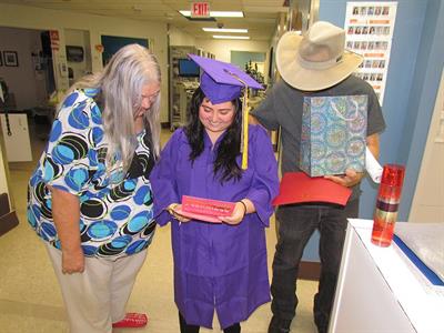 Deluna and her grandparents read a card from UTMB staff. 