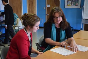 Amerisa Waters shows Laura Muruato how to fill out a patient assistance application.