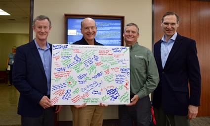 UT System Chancellor William McRaven (left), Exec. Vice Chancellor for Health Affairs Dr. Raymond Greenberg (far right), and Chief Compliance and Risk Officer Philip Dendy (middle right), present Dr. Callender with messages of support.
