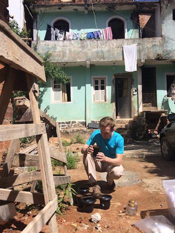 Chris Roundy checks a mosquito trap in a Brazilian neighborhood. Roundy traveled to Brazil recently as part of a team of researchers studying the Zika virus.
