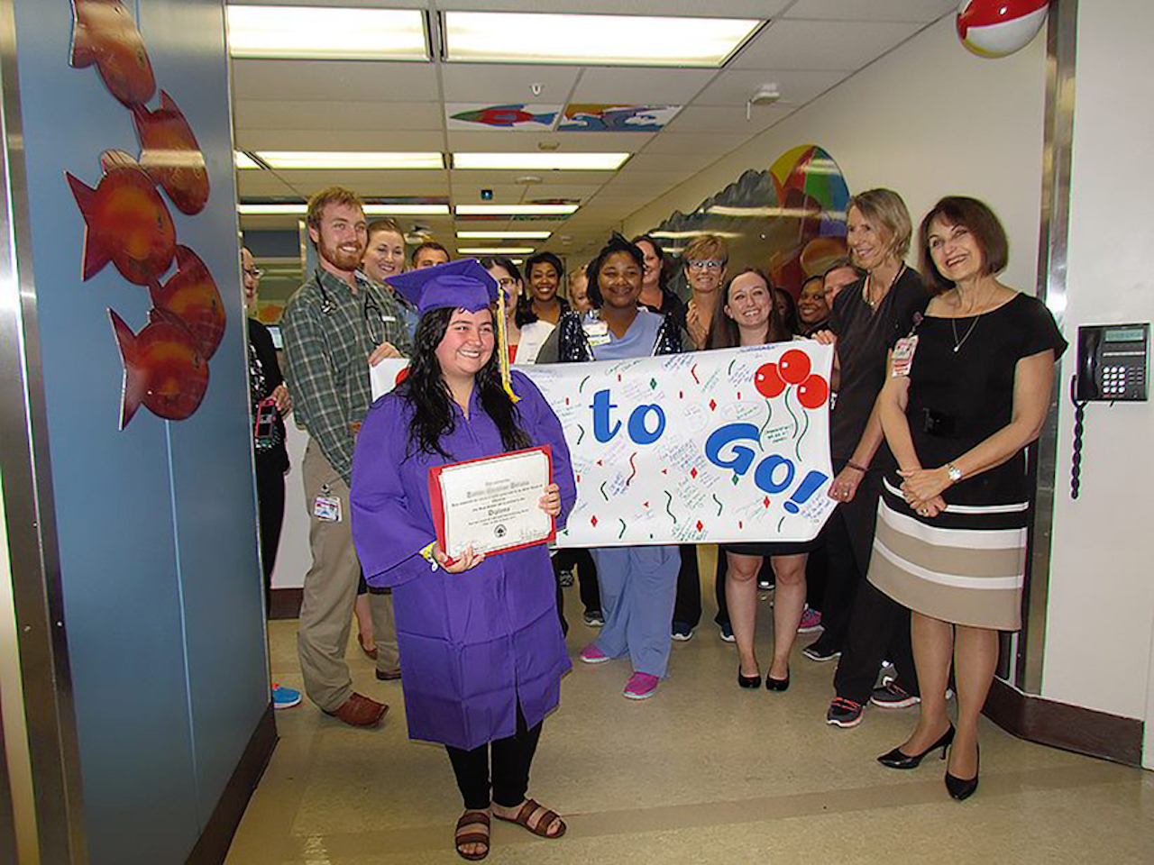 Taylor Deluna holds her diploma after being surprised by UTMB Children’s Hospital staff.