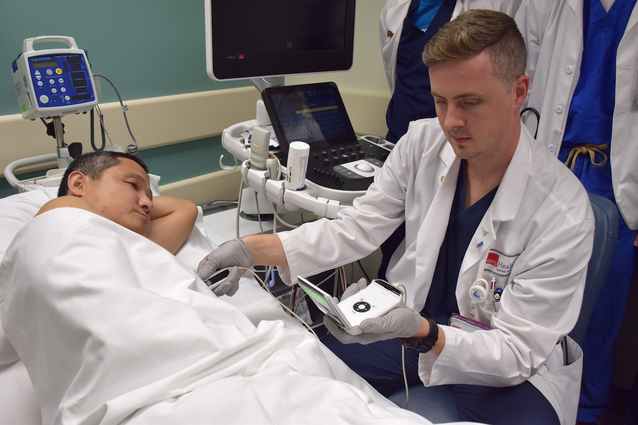 Chris Rice, a second-year School of Medicine student, practices using a handheld ultrasound device during the Point of Care Echocardiography course