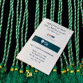 Alpha Omega Alpha Induction Ceremony program laying on top of tassels