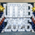 Illuminated sign that says UTMB 2026, between 2 columns made out of balloons