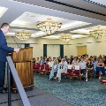 Dr. Bianco speaking on stage in front of audience