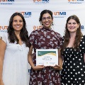 ΑΩΑ Student Vice President, Erin Guerra, and ΑΩΑ Student Treasurer, Gabrielle Hyde, presenting Faculty and House Staff Inductee Raakhi Menon, DO