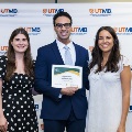 ΑΩΑ Student Vice President, Erin Guerra, and ΑΩΑ Student Treasurer, Gabrielle Hyde, presenting Faculty and House Staff Inductee Tejas Kollu, MD