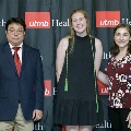 An individual stands for a portrait wearing green honor cords at the Alpha Omega Alpha 2023 Induction Ceremony at UTMB, in front of a UTMB Health and John Sealy School of Medicine backdrop.