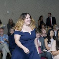 An individual walks through a ballroom aisle at the Alpha Omega Alpha 2023 Induction Ceremony at UTMB, with seated attendees visible on both sides.