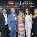 Five individuals stand together at the Alpha Omega Alpha 2023 Induction Ceremony at UTMB, posed in front of a UTMB Health and John Sealy School of Medicine logo backdrop with balloon decorations on either side.
