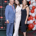 Three individuals pose together at the Alpha Omega Alpha 2023 Induction Ceremony at UTMB, standing beside a red, white, and gray balloon column with a UTMB Health backdrop.