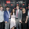 A group of six individuals pose together at the Alpha Omega Alpha 2023 Induction Ceremony at UTMB with a UTMB Health and John Sealy School of Medicine backdrop and balloon decorations on both sides.