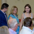 Three attendees stand and converse among seated audience members during an Alpha Omega Alpha Texas Alpha Chapter event at UTMB.