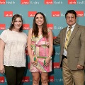 Three individuals stand together in front of a UTMB Health backdrop, with one wearing green honor cords, during an Alpha Omega Alpha Texas Alpha Chapter recognition event.