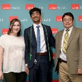 Three individuals stand together in front of a UTMB Health backdrop, one wearing green honor cords, during an Alpha Omega Alpha Texas Alpha Chapter recognition event.