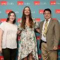 Three individuals stand together in front of a UTMB Health backdrop, with one wearing green honor cords, during an Alpha Omega Alpha Texas Alpha Chapter recognition event.