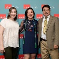 Three individuals stand together in front of a UTMB Health backdrop, one wearing green honor cords, during an Alpha Omega Alpha Texas Alpha Chapter recognition event.