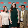 Three individuals stand together in front of a UTMB Health backdrop, with one wearing green honor cords, during an Alpha Omega Alpha Texas Alpha Chapter recognition event.