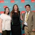 Three individuals stand together in front of a UTMB Health backdrop, with one wearing green honor cords, during an Alpha Omega Alpha Texas Alpha Chapter recognition event.