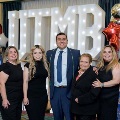 Seven individuals pose together in front of illuminated “UTMB 2024” letters with red, white, and gold balloon decorations at an Alpha Omega Alpha Texas Alpha Chapter event.