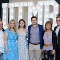 Six individuals stand in front of illuminated “UTMB 2024” display holding large gold “MD” balloons with red, white, and gold decorations at an Alpha Omega Alpha Texas Alpha Chapter event.