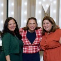 Three individuals stand together in front of illuminated “UTMB” letters with decorative balloons at an Alpha Omega Alpha Texas Alpha Chapter event at the University of Texas Medical Branch.