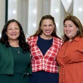 Three individuals pose together in front of illuminated “UTMB” letters at an Alpha Omega Alpha Texas Alpha Chapter event at the University of Texas Medical Branch.