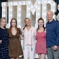Five individuals stand together in front of illuminated “UTMB” letters with red, white, and gold balloons at a celebratory event for Alpha Omega Alpha Texas Alpha Chapter.