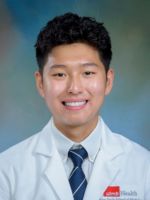 professional headshot of Daniel Cho with short black hair, wearing a blue striped tie and white coat